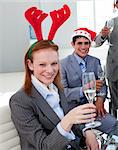 Portrait of a smiling businesswoman toasting with her colleagues at a Christmas party