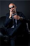 businessman smoking and drinking sitting on a sofa