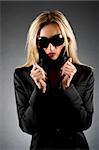 fashion model wearing sunglasses and a black raincoat