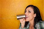 Attractive Hispanic woman with tin can telephone