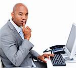 Confident businessman asking for silence sitting at his desk in the office