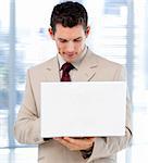 Concentrated businessman using a laptop standing in the office