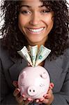 Smiling woman holding piggy bank