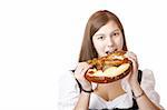 Young attractive woman bites in Oktoberfest Pretzel. Isolated on white background.