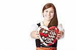 Bavarian woman in love holds Oktoberfest heart. Isolated on white background.