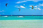 Kitesurfers gliding at high speed around the beach Cinta, Sardinia