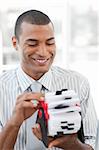 Attractive businessman consulting a business card holder at work