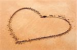 Heart shape symbol drawn on sandy beach