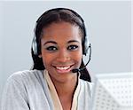 Charismatic businesswoman using headset at her desk in the office