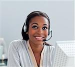 Delighted businesswoman using headset at her desk in the office