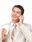 Young businessman on phone while drinking a coffee against a white background