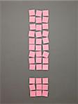 Exclamtion Mark made of Pink Adhesive Notes on grey background