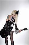 Sexy gothic girl playing guitar, studio shot over white background