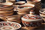 Rustic handmade ceramic pot and clay brown pottery decorated by traditional ornament and pattern at the handicraft market