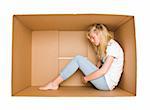 Woman siting in a cardboard box isolated on white background