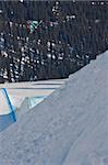 Young snowboarder catching air on a huge park kicker in Laax - Switzerland