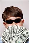 Money Man.Boy holding a fan of one hundred dollar bills
