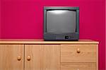 TV set in a room with red wall