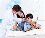 Charming doctor playing with a little boy and his mother at the hospital