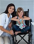 Cute girl sitting on a wheelchair with a female doctor in the hospital