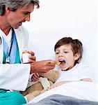 Child taking cough medicine in hospital
