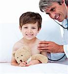 Mature doctor checking little boy's pulse in a hospital