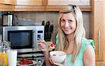 Attractive young woman having an healthy breakfast in a kitchen at home