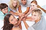 Smiling Teenagers lying on the floor in a circle playing hands games at home