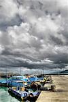 Bad weather of storm in harbor with fishing boats on pier.