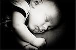 New born baby boy sleeping peacefully, black and white photograph.