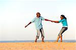 African American couple hand in hand on the beach