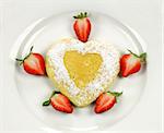 Delightful heart shaped pancake with fresh strawberries.