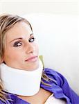 Young woman with a neck brace looking in the camera against white background