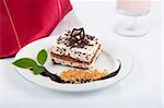 Sweet chocolate dessert with nuts and chocolate on white plate and red napkin