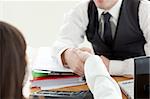 Close-up of two business partners shaking hands in the office