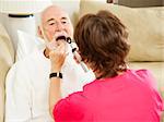 Home health care nurse looks in a patient's throat.