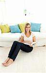 Cute woman reading a book in the living-room at home