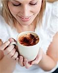 Delighted woman drinking a coffee at home