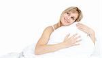 Cheerful woman hugging her pillow on her bed
