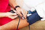 Nurse taking a patient's blood pressure using a sphygmomanometer.  Closeup view.