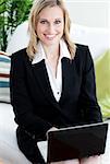 Confident businesswoman with  a laptop smiling at the camera