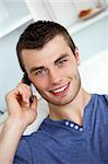 Friendly man on phone sitting on a couch in living room