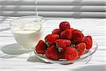 Plate with berries of a fresh strawberry and a cup with yoghurt (sour cream)