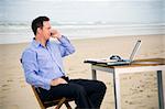 Business man with office on the beach