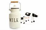 Milk urn white pot with blurred toy cows isolated on white