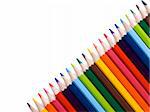 Colored pencils form a diagonal over a white background. Copy space.