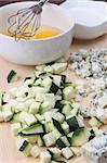 Cutting board with ingredients for zucchini omelet. Shallow DOF