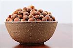 Bowl with hazelnuts on a wooden table. Shallow DOF