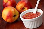 Nectarine jam in a white bowl and fresh nectarines