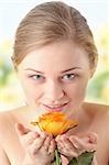 Sensual portrait of young nude sexy blond woman with orange rose